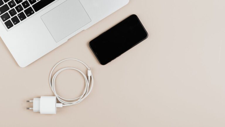 A smartphone and laptop set up to back up iPhone photos