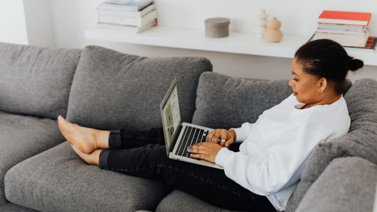 A woman relaxing at home using a protected laptop