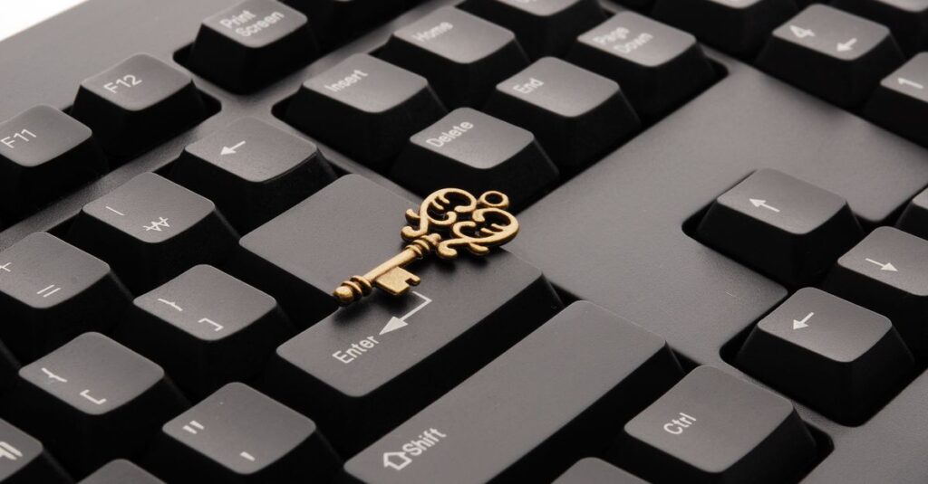 An ornate golden key resting on the enter key of a keyboard