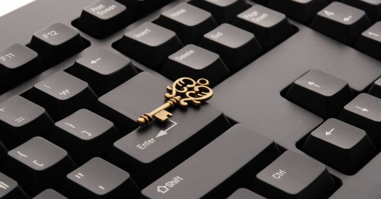 An ornate golden key resting on the enter key of a keyboard
