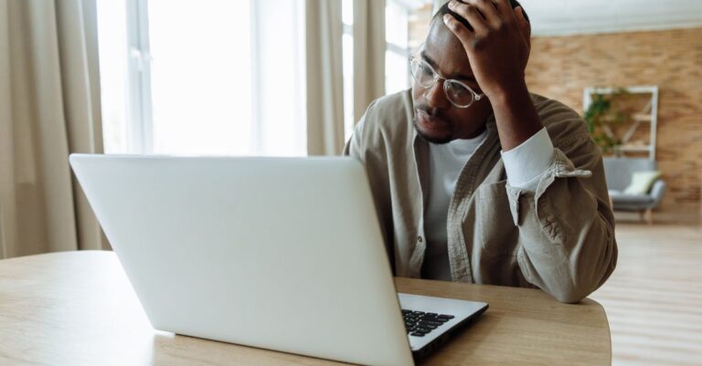 Person stressed by the Google account recovery loop at a laptop