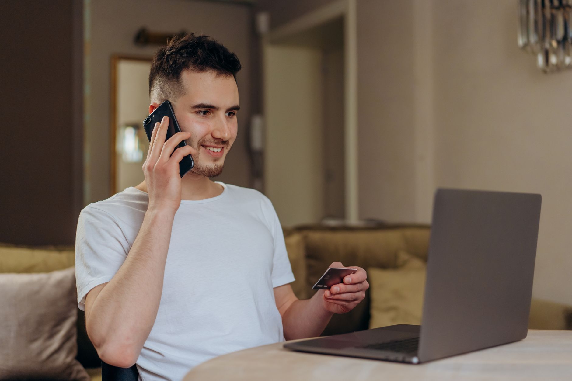 Person setting up an online payment account on a laptop at a kitchen table
