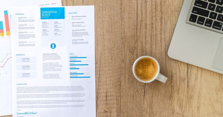 A resume and laptop on a desk, ready for job applications