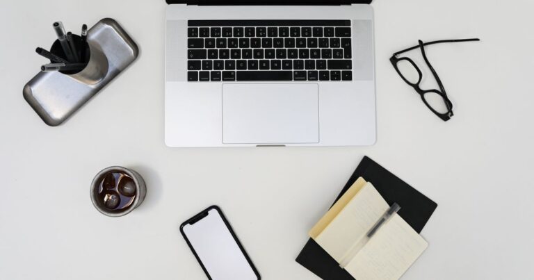 A tidy desk with a laptop and phone for comparing email options