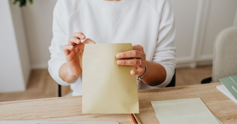 A person holding a sealed envelope, symbol of private email