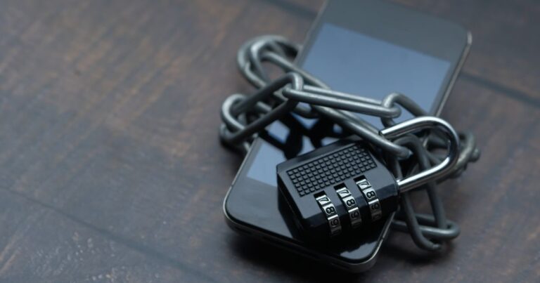 A smartphone wrapped in a chain and padlock, symbol of protection